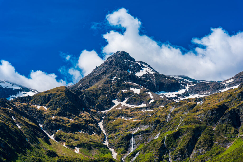 Towering alpine peaks with snowfields and waterfalls in Sportgastein, Hohe Tauern National Park, Austria.