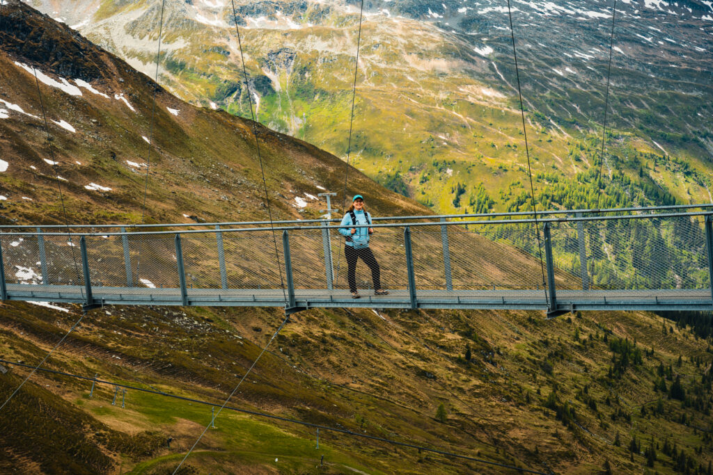 Visitor crossing the 140-meter Stubnerkogel Suspension Bridge above the Gastein Valley in the Austrian Alps.