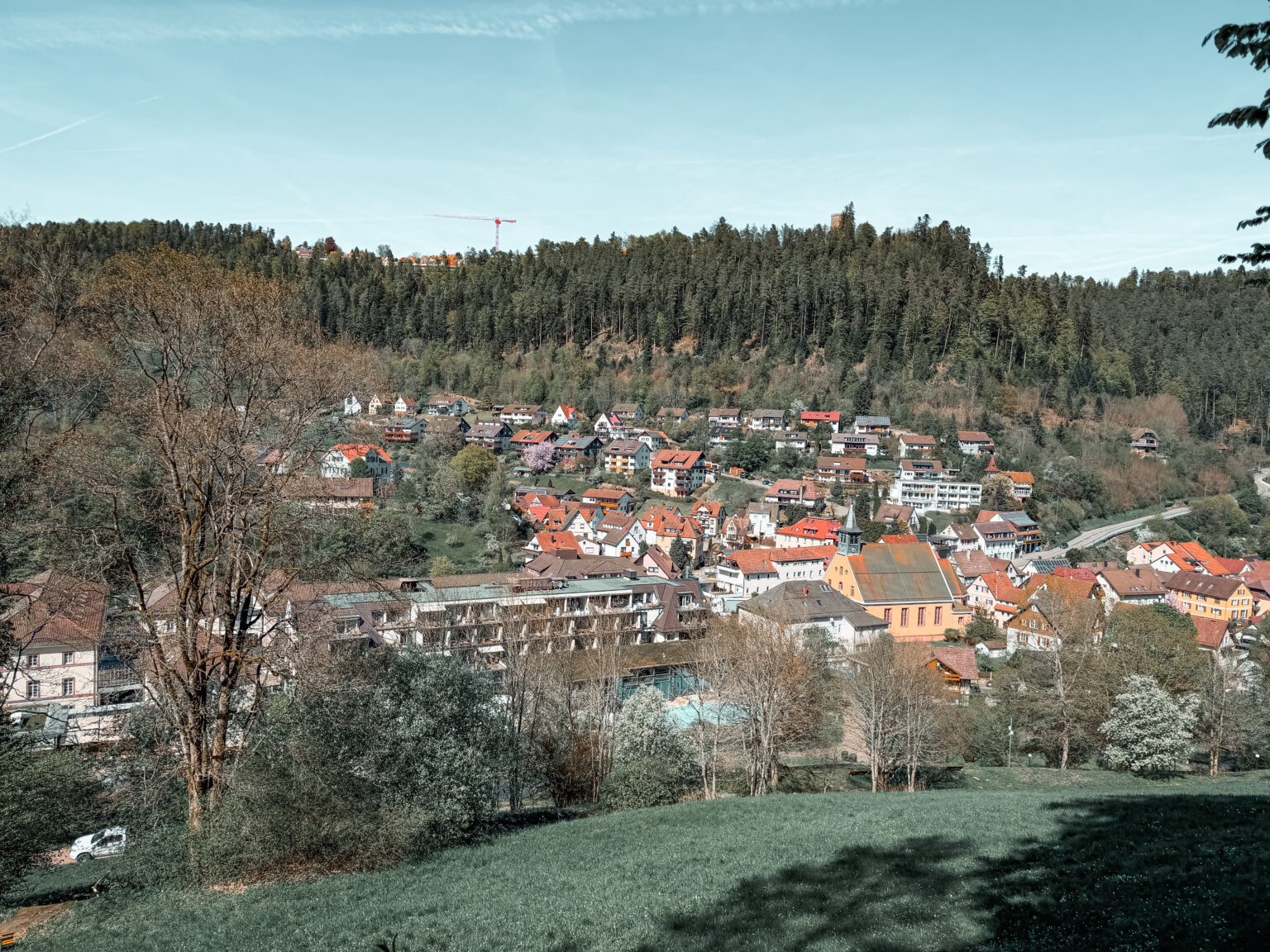 Panoramic view of Bad Teinach-Zavelstein in Germany’s Black Forest with the Dreifaltigkeitskirche, Hotel Therme Bad Teinach and surrounding forest landscape.
