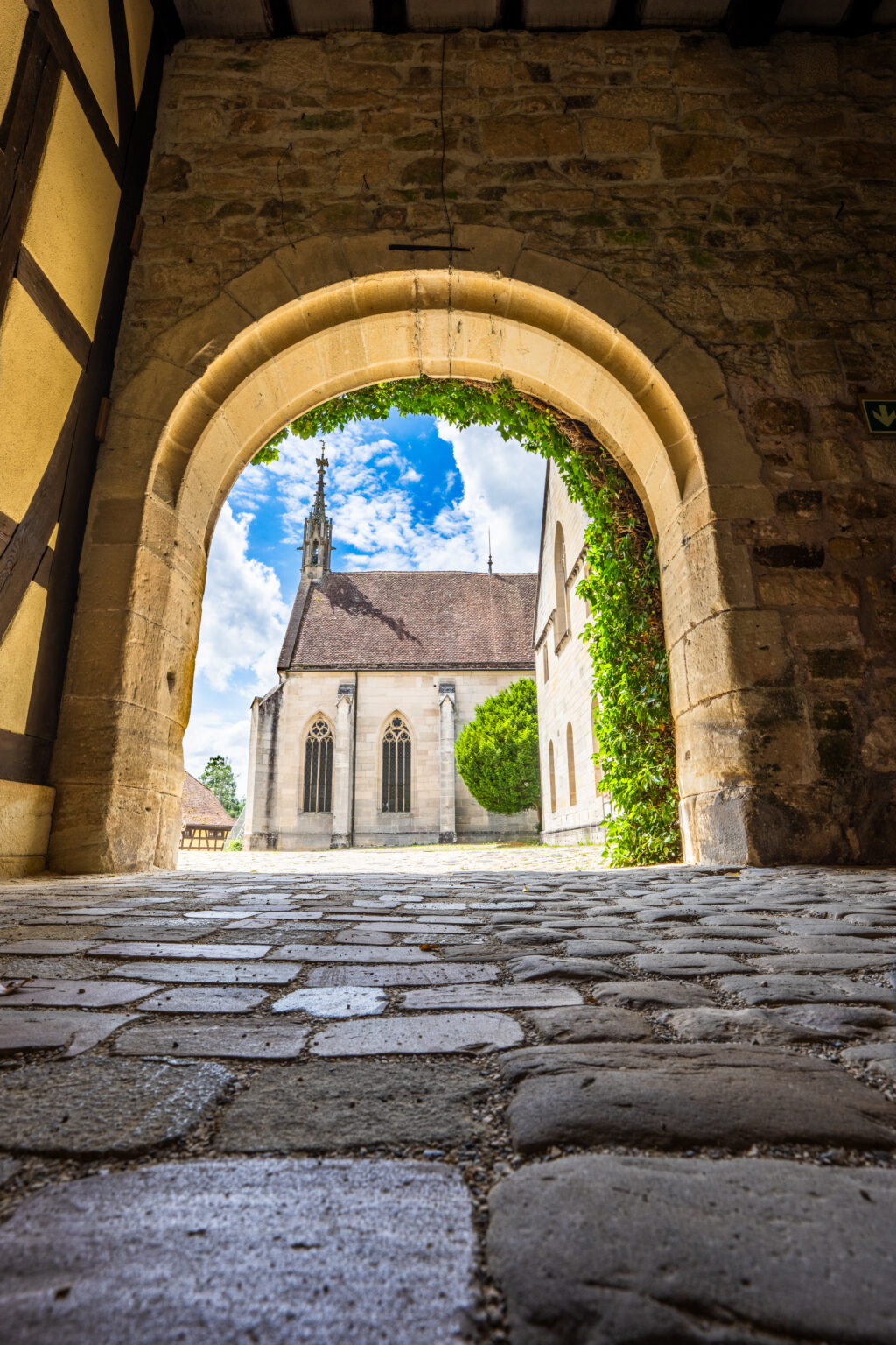 Stone archway at Bebenhausen Abbey framing the historic monastery church and medieval architecture in Baden-Württemberg, Germany.