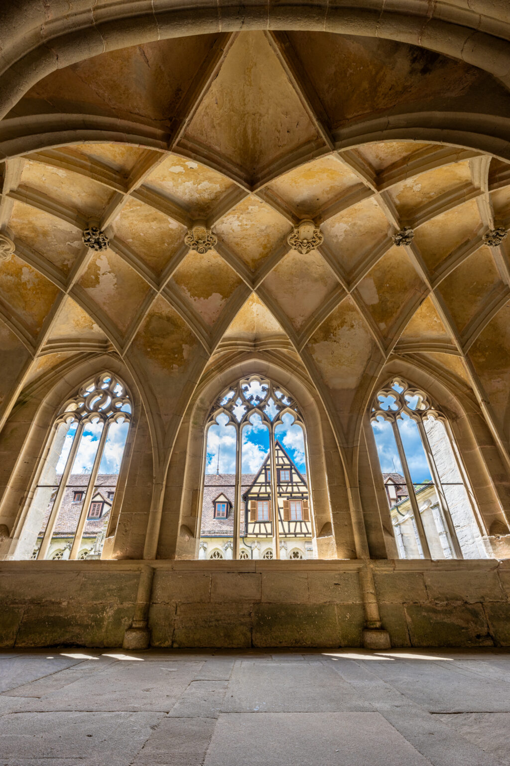Gothic windows and vaulted ceiling inside Bebenhausen Abbey featuring medieval stone architecture and intricate architectural details.